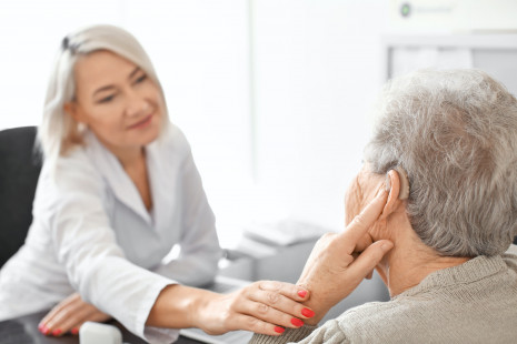 Woman adjusting a hearing aid